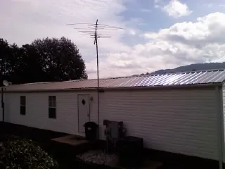 New metal roof on a single wide mobile home with a TV antenna in Midway